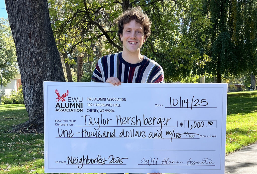 Photo of scholarship winner holding a big fake check.